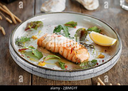 Baked salmon fillet steak with lemon and herbs Stock Photo