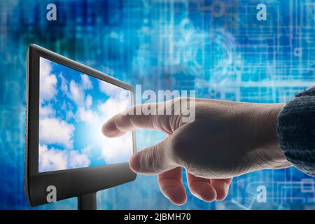 hand touching a screen with clouds into it, cloud computing concept Stock Photo