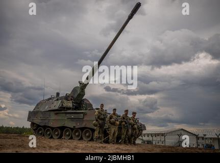 Pabrade, Lithuania. 07th June, 2022. Soldiers stand in front of an armored self-propelled artillery piece of the Bundeswehr howitzer 2000 type used by the NATO Enhanced Forward Presence Battle Group (eFP battalion) during Chancellor Scholz's visit to Camp Adrian Rohn. Scholz pledged additional military support to Lithuania to defend against a possible Russian attack. Credit: Michael Kappeler/dpa/Alamy Live News Stock Photo
