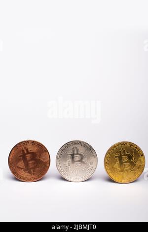 KYIV, UKRAINE - APRIL 26, 2022: Close up view of different bitcoins on white background with copy space Stock Photo