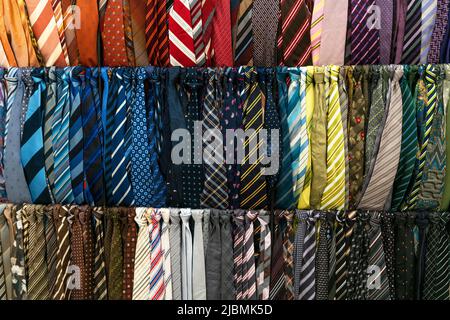 A selection of ties or neckties on display for sale in a mens fashion clothes shop or store Stock Photo