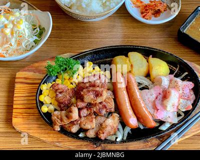 Various menus, sushi, sashimi, nigiri, pan fried pork and miso soup. Sashimi, chutoro sashimi, Japanese food chopsticks and wasabi on the black table, Stock Photo