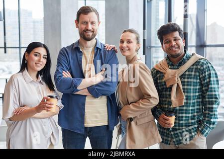 Diverse group of adult people looking at camera and smiling while wearing business casual outfits Stock Photo