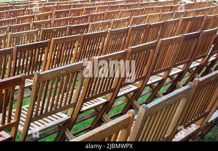 Rows of empty wooden chairs shot in landscape format with a telephoto lens Stock Photo
