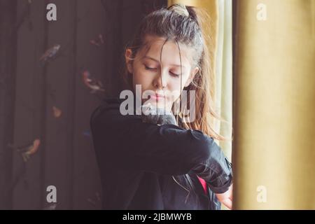 Teenage girl with pet hamster on arm at home - winter white dwarf in sapphire Stock Photo