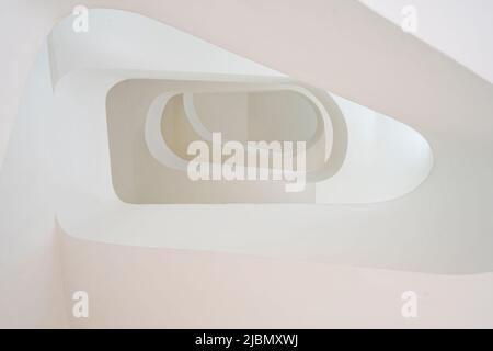 Looking up a modern stone built spiral staircase Stock Photo