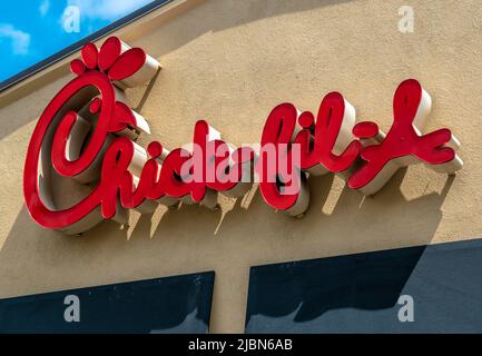 https://l450v.alamy.com/450v/2jbn6ab/chick-fil-a-exterior-facade-brand-and-logo-signage-in-red-script-lettering-above-black-awnings-on-a-sunny-day-with-blue-sky-and-clouds-in-charlotte-2jbn6ab.jpg