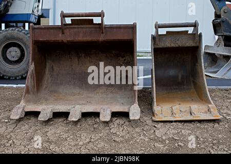 closeup of two different sized excavator buckets Stock Photo