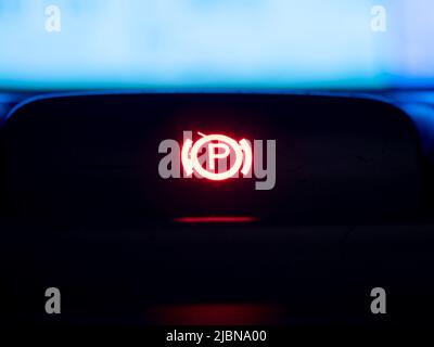 Red illuminated hand brake sign close-up. Stock Photo