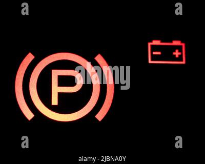 Red illuminated hand brake sign close-up. Stock Photo