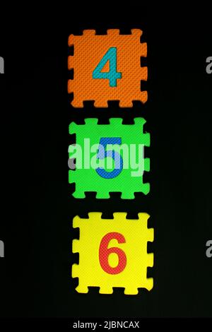 Colorful number puzzle isolated on black background. Number learning block for children education. Stock Photo