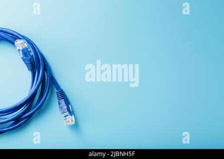 Blue Ethernet Cable Connectors Patch cord cord close-up isolated on a blue background with free space Stock Photo