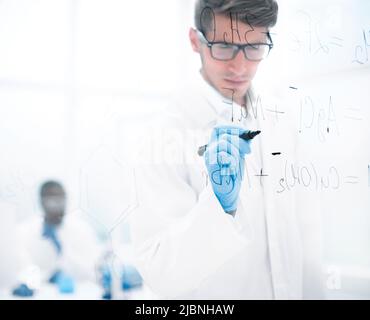 scientist making notes on the glass Board at the time of the experiment Stock Photo