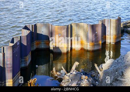 Temporary corrugated steel plate retaining wall during the strengthening and reconstruction of the river bank Stock Photo