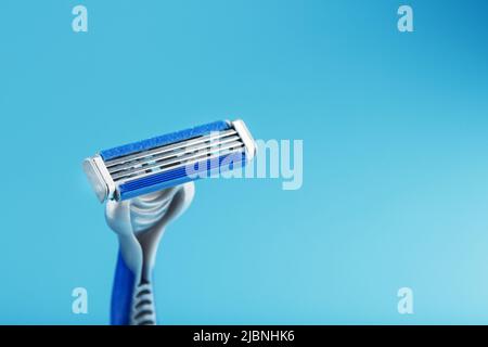 Blades of a new shaving machine on a blue background close-up free space Stock Photo
