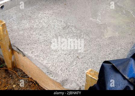 Freshly laid concrete on a building site with marks left by overnight rain Stock Photo