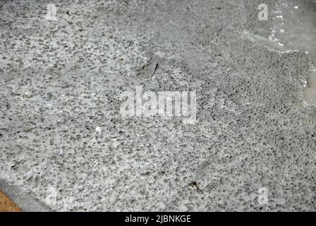 Freshly laid concrete on a building site with marks left by overnight rain Stock Photo