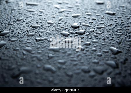 water spray droplets on black metallic surface Stock Photo