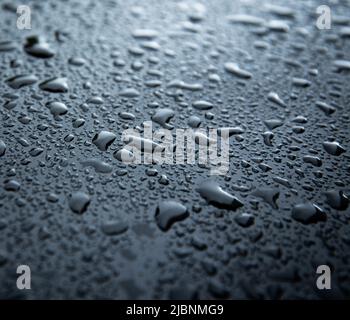 water spray droplets on black metallic surface Stock Photo