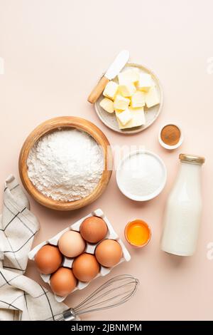 Baking ingredients for cakes bread cookies or pastry on beige background. Top view vertical orientation. Stock Photo