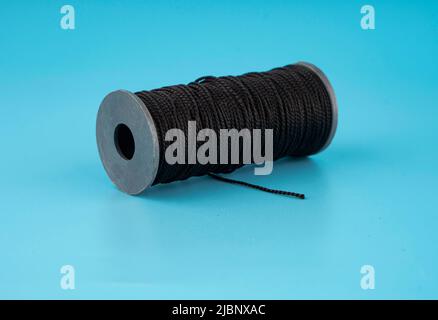 skein of black dense threads, on a blue background Stock Photo