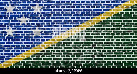 Close-up on a brick wall with the flag of the Solomon Islands painted on it. Stock Photo