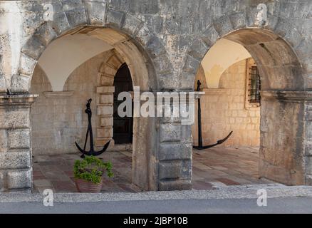 Looking into the archways of an ancient building on the Bay of Kotor at some old metal anchors Stock Photo