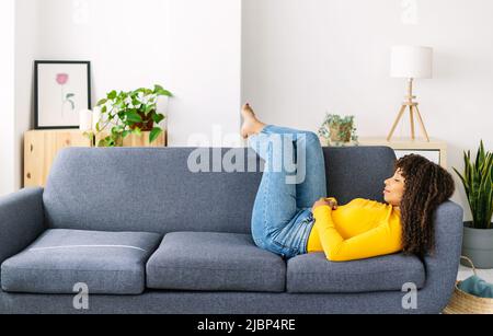 Young woman relaxing on sofa at home Stock Photo
