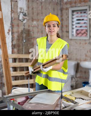 Female carrying wooden panel on construction site Stock Photo
