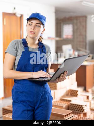 Young woman builder using laptop in construction site Stock Photo
