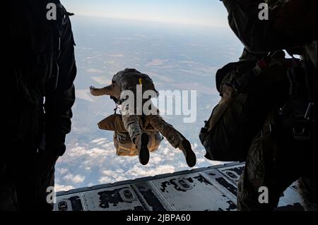 Members of the Armée de l'Air et de l’Espace (French Air and Space Force) execute a military free fall from a U.S. Air Force MC-130J Commando II assigned to the 352d Special Operations Wing near Cazaux Air Base, France, May 10, 2022. The MFF was part of exercise Athena, a French-led joint and combined Special Operation Forces exercise that validates the full spectrum of integrated component and partner capabilities. Exercises like Athena allow U.S. service members to train at the operational and tactical echelon as a combined, joint force with SOF setting the conditions for larger operations. Stock Photo