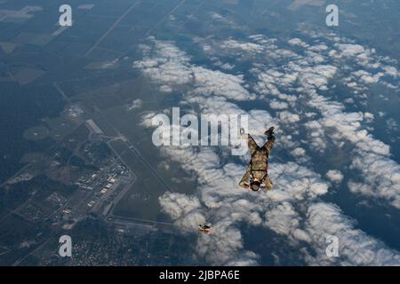 Members of the Armée de l'Air et de l’Espace (French Air and Space Force) execute a military free fall from a U.S. Air Force MC-130J Commando II assigned to the 352d Special Operations Wing near Cazaux Air Base, France, May 10, 2022. The MFF was part of exercise Athena, a French-led joint and combined Special Operation Forces exercise that validates the full spectrum of integrated component and partner capabilities. Exercises like Athena allow U.S. service members to train at the operational and tactical echelon as a combined, joint force with SOF setting the conditions for larger operations. Stock Photo