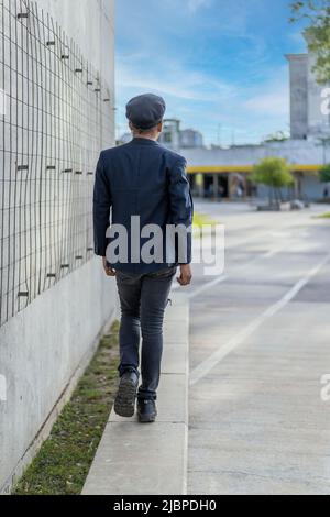 Latin gay male wearing fashion hat doing catwalk in the street Stock Photo