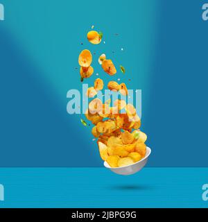 Potato chips falling onto plate on white background. Advertising concept. Levitation flying chips Stock Photo