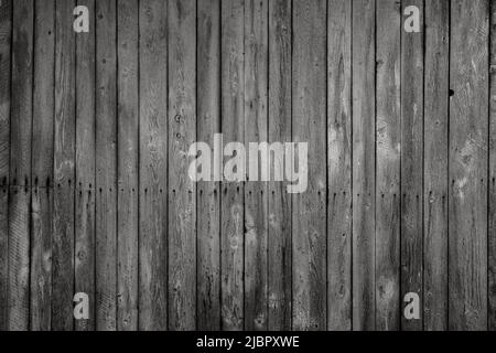 Front view of an old, weathered and dark wooden wall in black and white. Abstract full frame textured background. Stock Photo