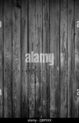 Front view of an old, weathered and dark wooden wall in black and white. Abstract full frame textured background. Stock Photo