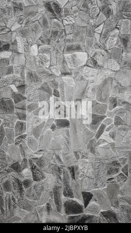 Front view of stone wall made of weathered stone slates. Abstract high resolution full frame textured background in black and white. Stock Photo