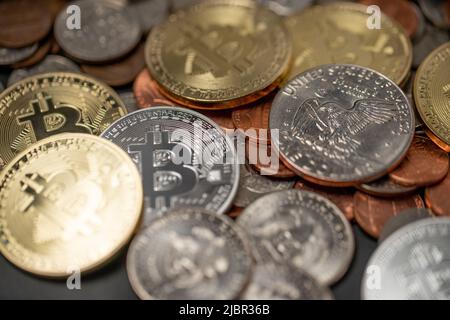A pile of coins, US Dollar coins next to Crypto coins. Gold and Silver Bitcoins. Digital Currency concept. Trading USD with BTC Stock Photo