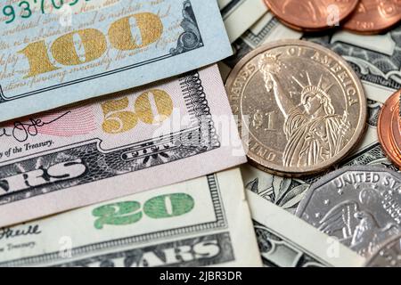 US Dollar Banknotes with shiny denomination numbers from twenty to one hundred USD, Banknotes next to Dollar coins, 1 Dollar coin Stock Photo