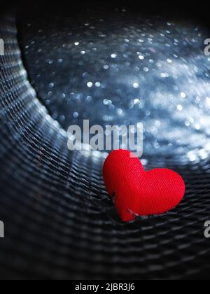 red heart breaks free through a metal grate. macro. a photo Stock Photo