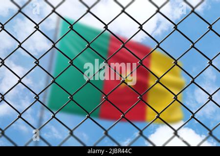 A steel mesh against the background of a blue sky and a flagpole with the flag of cameroon Stock Photo