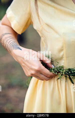 Midsummer solstice ritual. Celebrating summer solstice. Significance of the solstice in Paganism. Woman with herbs wreath on nature background Stock Photo