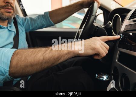 Male Driver Pushing Control Button On Panel Driving Car, Cropped Stock Photo