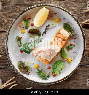 Baked salmon fillet steak with lemon and herbs Stock Photo