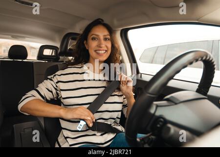Arabic Female Driver Putting On Seat Belt Sitting In Car Stock Photo