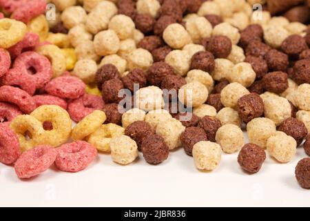 A set of different quick breakfast cereals - rings and balls, top view on white. Stock Photo