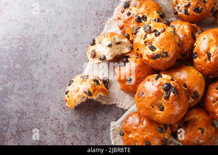 Freshly baked buns with raisins traditional european pastry close-up on the table. horizontal top view from above Stock Photo