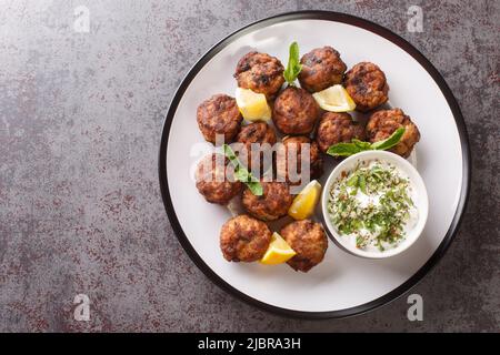 Keftedakia is a Greek traditional dish that is created with minced beef and bread crumbs rolled into balls and fried closeup on a white plate on a tab Stock Photo