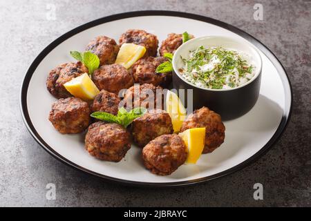 Keftedakia is a Greek traditional dish that is created with minced beef and bread crumbs rolled into balls and fried closeup on a white plate on a tab Stock Photo