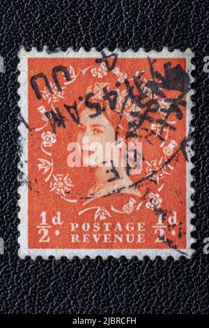 Potsdam, Germany - APR 26, 2022. A old of Great Britain (United Kingdom) issued stamp with portrait of Queen Elizabeth II with postmark on a black lea Stock Photo